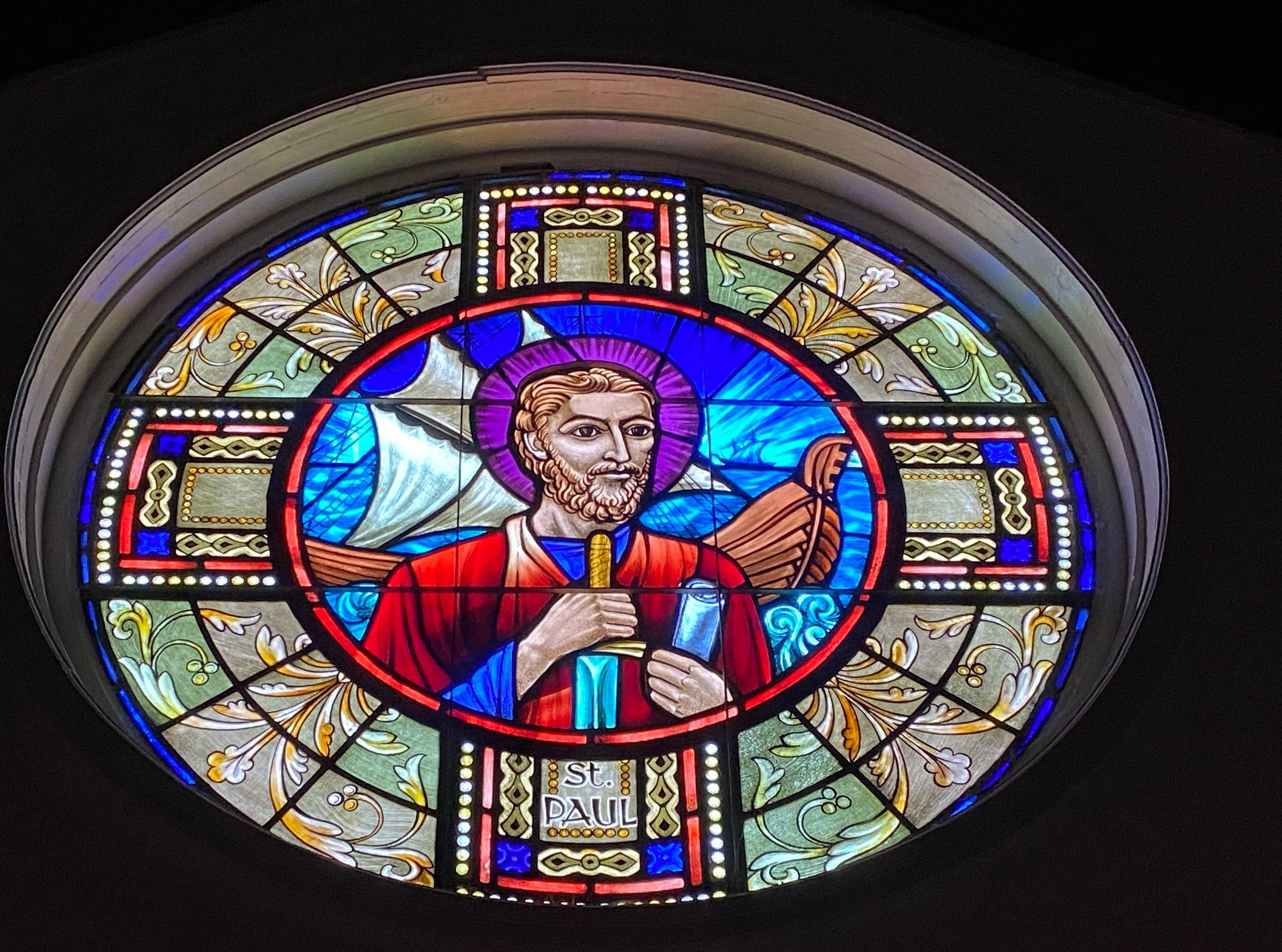 a stained glass window with a man holding a candle