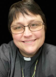 a woman wearing glasses and a priest's outfit
