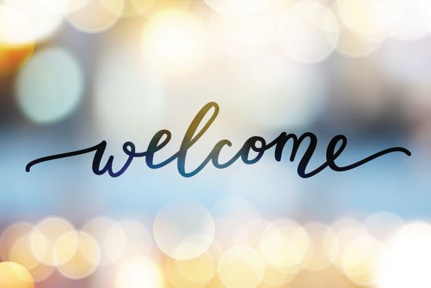 the word welcome written in cursive ink on a glass surface
