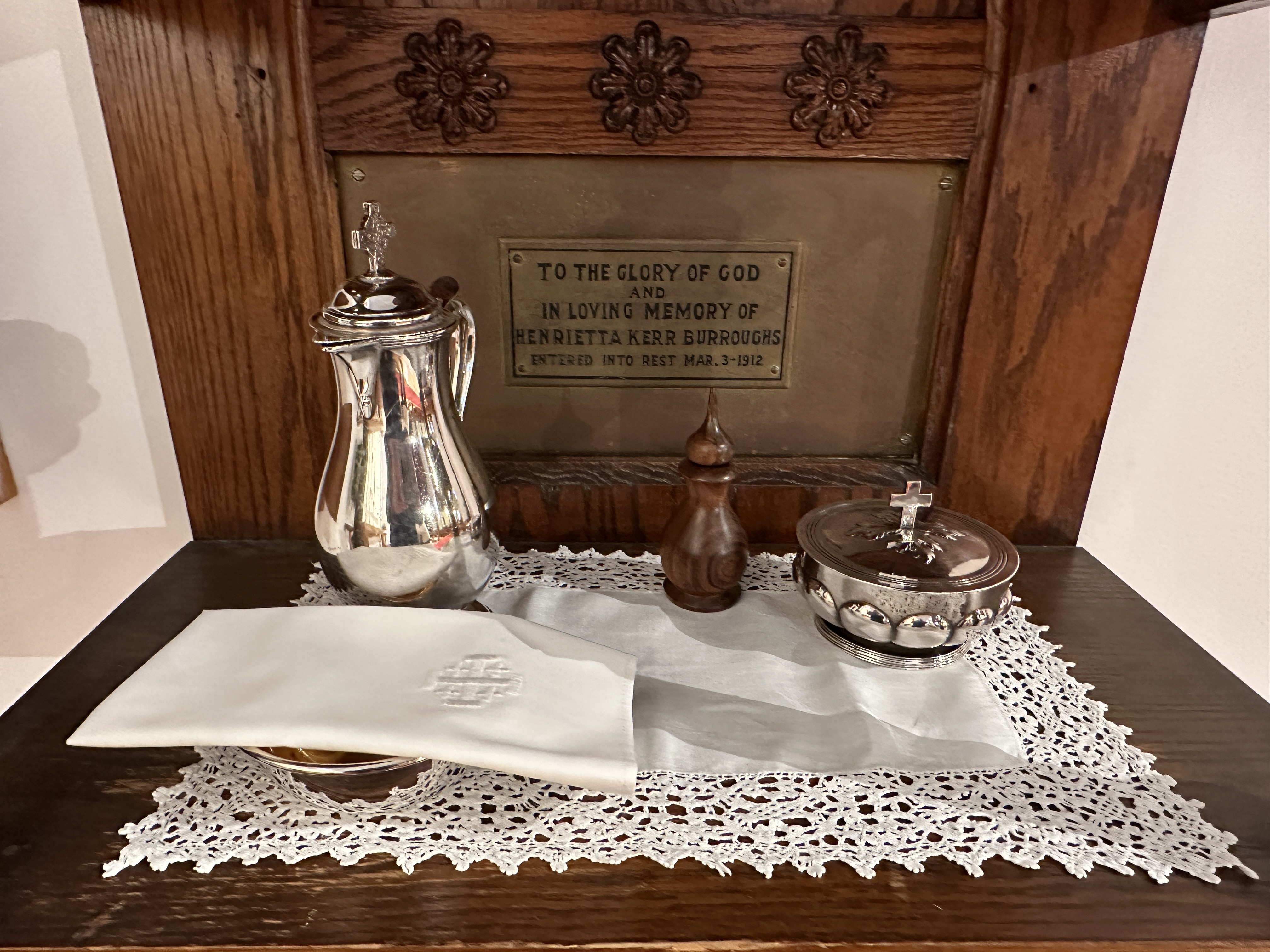 a table topped with a silver pitcher next to a white napkin